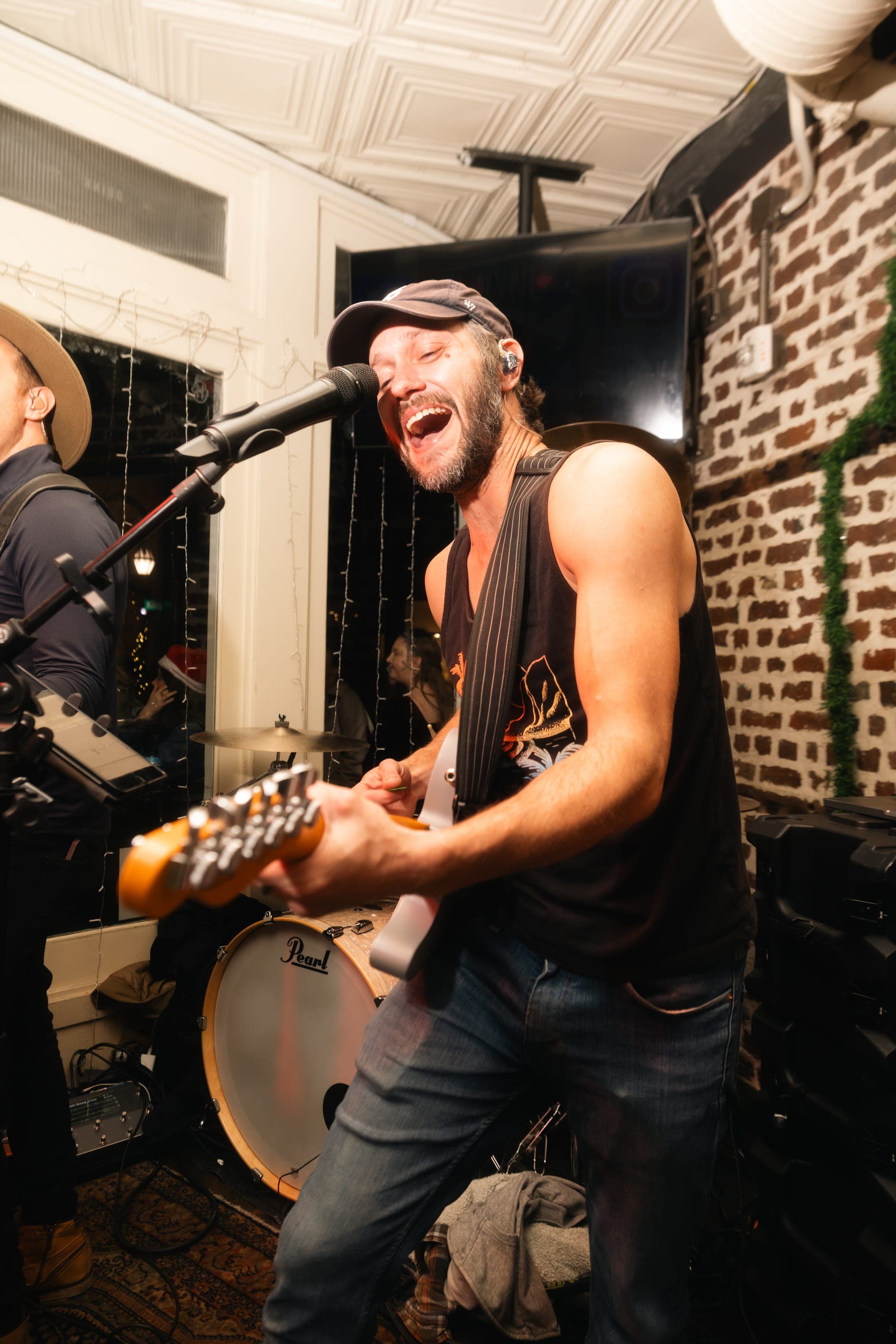 Guitarist mid-song, grinning at the mic